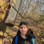 ourdoor school participant with woodpecker log